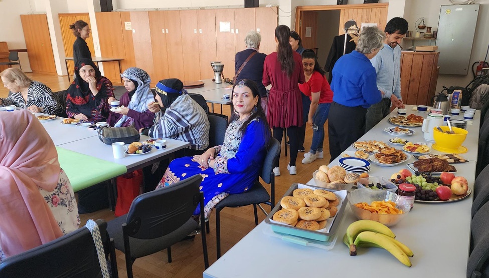 Buffet uns Frauen, die an Tischen sitzen und essen und trinken Buffet uns Frauen, die an Tischen sitzen und essen und trinken