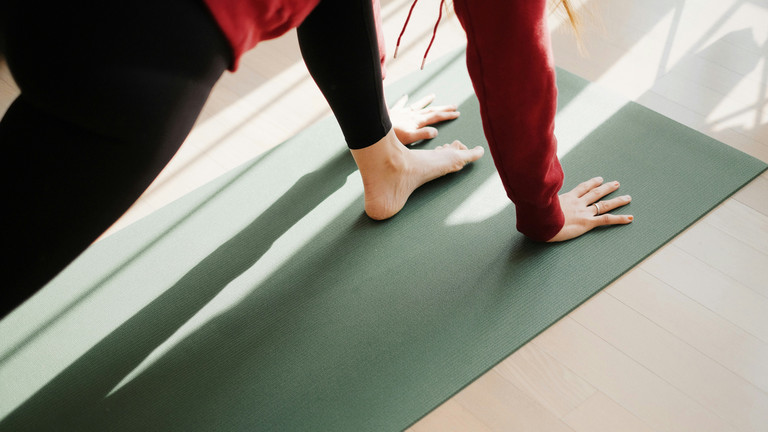 Frau bei macht Übung auf einer Pilatesmatte