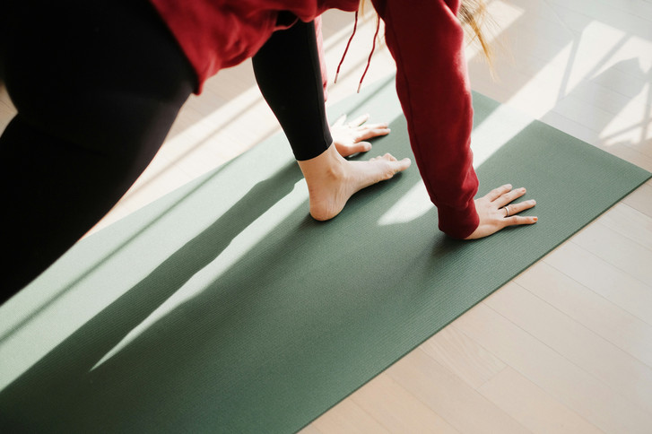 Frau bei macht Übung auf einer Pilatesmatte