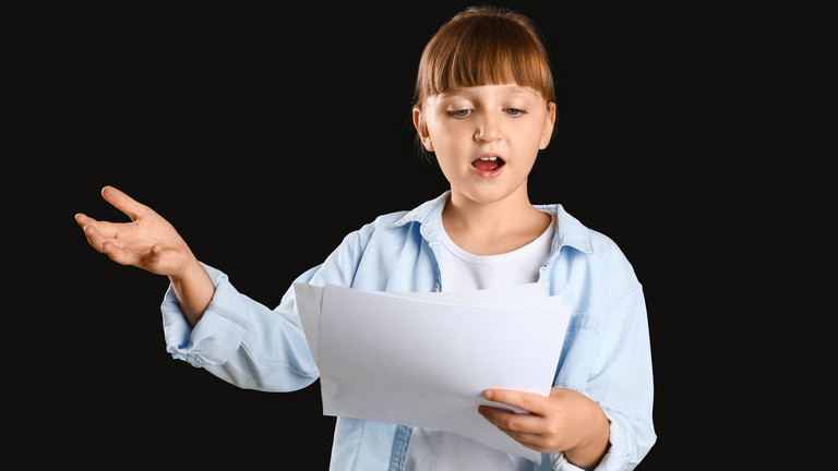 Ein Mädchen liest von einem Blatt vor