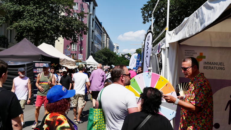 Stand mit Glücksrad und vielen Menschen