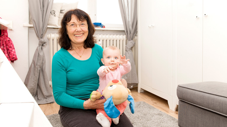 Ehrenamtliche mit Baby auf Schoß