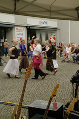 Mehrere tanzende Menschen auf einem gepflasterten Platz beim Musikfestival Fête de la Musique vor dem Immanuel Stadtteilzentrum Borsigwalde in Berlin-Reinickendorf.