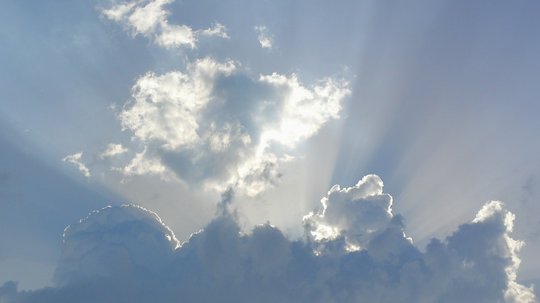 Ein blauer Himmel mit mehreren Wolken und Sonnenstrahlen als Motiv für die Veranstaltungsreihe Zukunftsgeschichten - Gesprächskreis mit wechselnden Themen im Immanuel Stadtteilzentrum Schöneberg in Berlin-Schöneberg