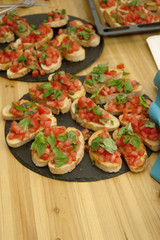 Mehrere große Teller mit Bruschetta mit frischen Tomaten und Kräutern auf einem Holztisch beim Musikfestival Fête de la Musique im Immanuel Stadtteilzentrum Borsigwalde in Berlin-Reinickendorf.