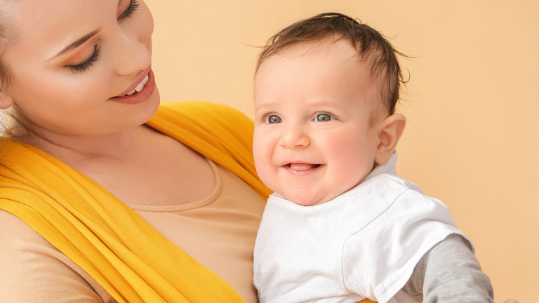 Frau mit einem Baby im Tragetuch