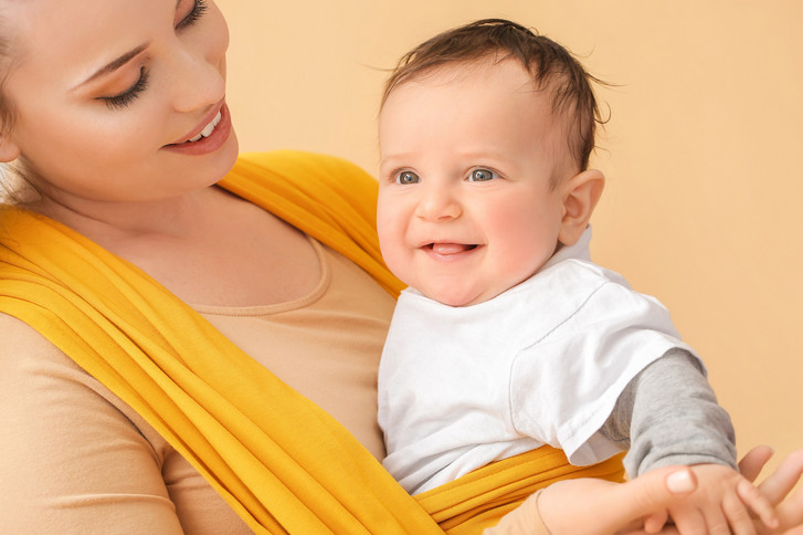 Frau mit einem Baby im Tragetuch