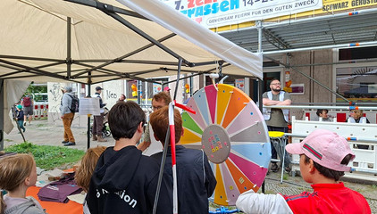 Der Infostand von Immanuel Beratung, Immanuel Dialog und Förderverein Beratung + Leben e.V. mit einem Menschen an einem Glücksrad beim 7. Zelterstraßenfest mit der Immanuel Beratung Prenzlauer Berg in Berlin. Der Infostand von Immanuel Beratung, Immanuel Dialog und Förderverein Beratung + Leben e.V. mit einem Menschen an einem Glücksrad beim 7. Zelterstraßenfest mit der Immanuel Beratung Prenzlauer Berg in Berlin.