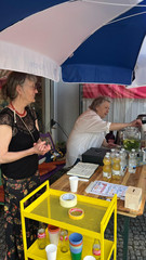 Zwei ehrenamtliche Helferinnen bieten kalte Getränke und Kuchen an einem Stand beim Musikfestival Fête de la Musique auf dem Platz vor dem Immanuel Stadtteilzentrum Borsigwalde in Berlin-Reinickendorf an.