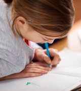 Ein Mädchen schreibt etwas in ein Heft, Angebot Unterstützung für Kinder, Immanuel Beratung + Leben, Stadtteilzentrum Borgiswalde, Berlin